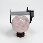 Rose quartz crystal ball sphere with caliper measurement, polished light pink