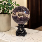 Amethyst druzy sphere on ornate black base, purple with crystal sparkle