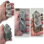 Moss agate drusy tower held in hand; dark green stone with white crystal clusters