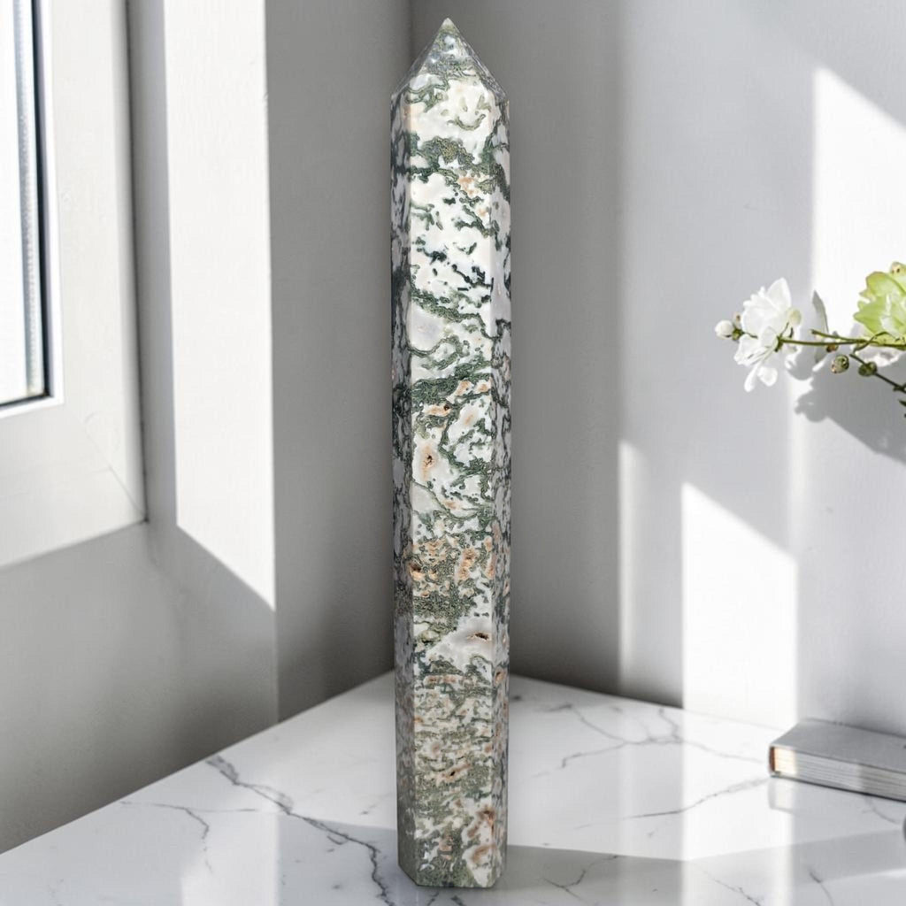Moss agate obelisk point, tall green-and-white stone with dark veining.