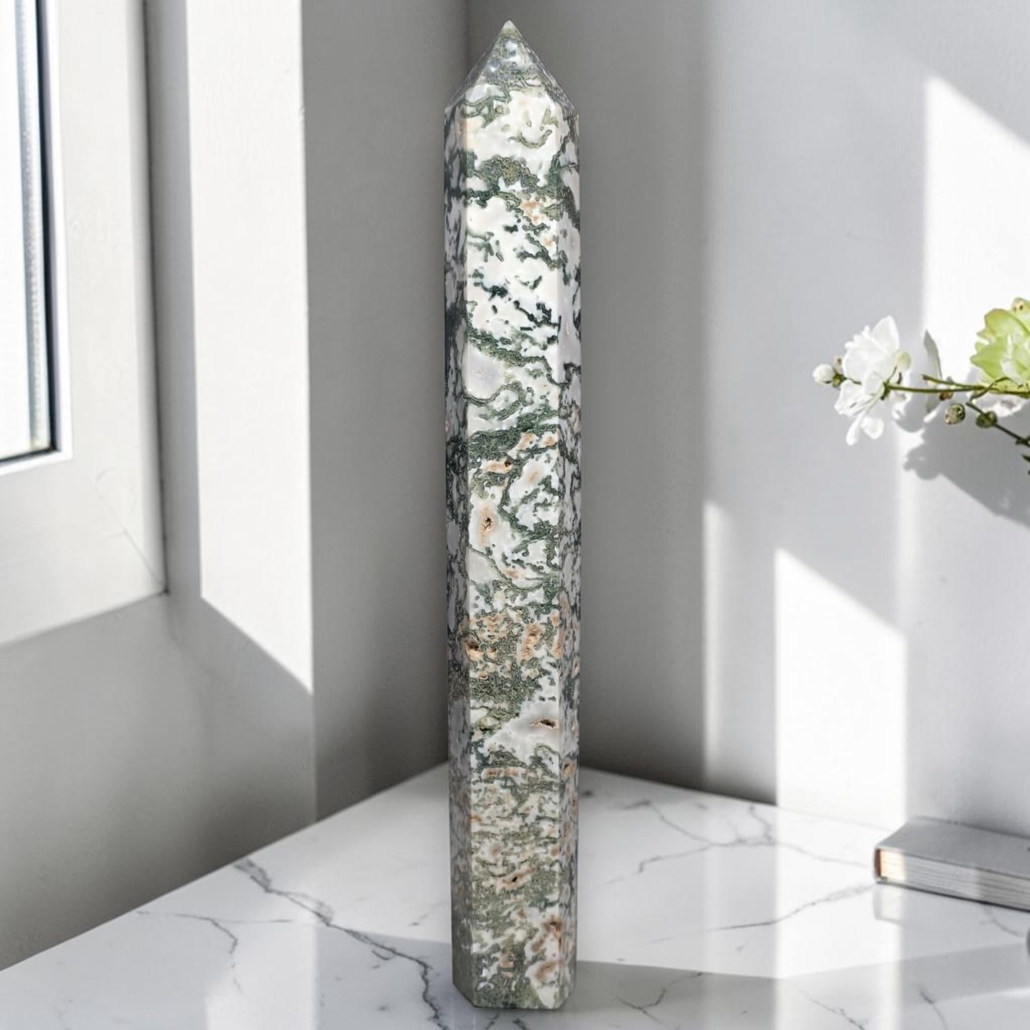 Moss agate obelisk point, tall green-and-white stone with dark veining.