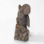 Dolphin crystal sculpture in brown-gray stone, carved fins and curled tail