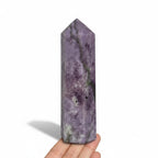 Purple crystal obelisk tower, held in hand, with pointed top