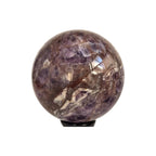 Amethyst quartz crystal sphere on black stand, purple stone with light-reflecting inclusions