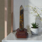 Blue and gold kyanite crystal tower on dark red carved wooden base