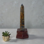 Blue and gold kyanite crystal tower on dark red wooden stand