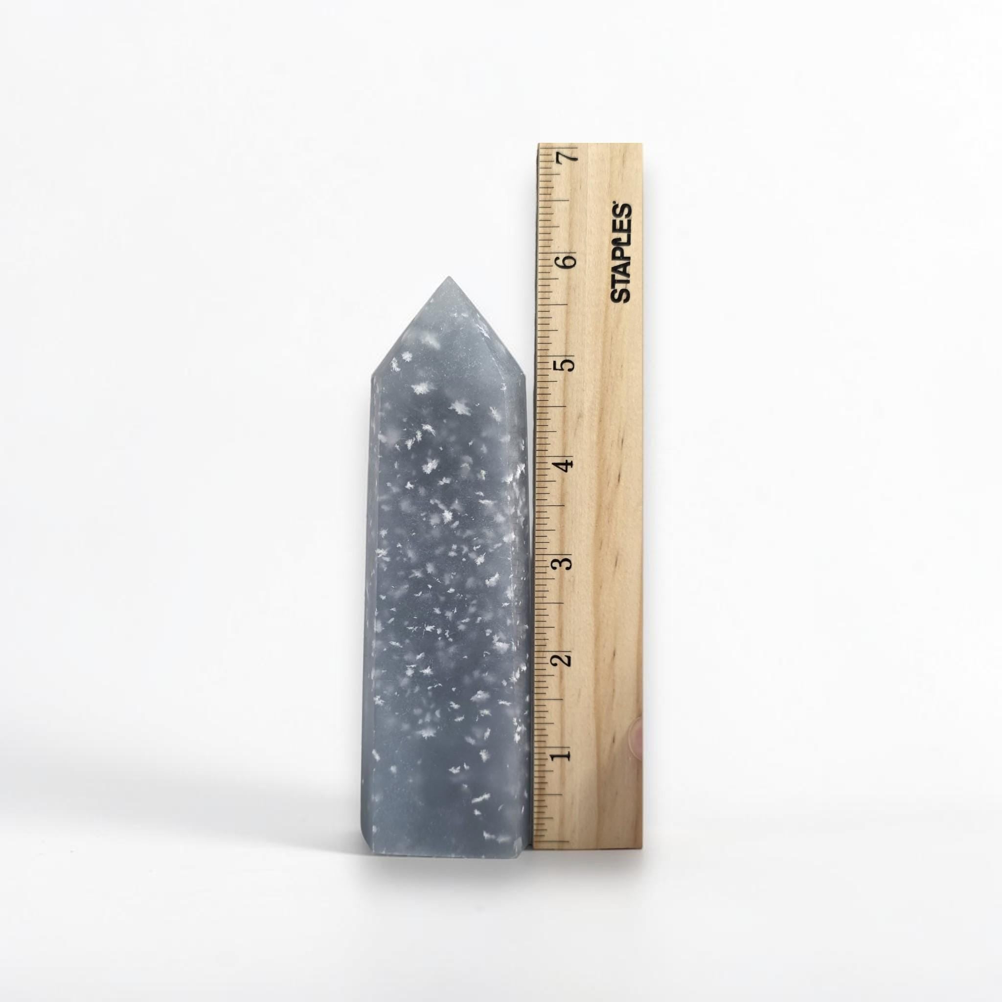 Blue angelite tower next to ruler, pointed top with white speckled pattern.