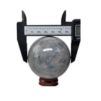 Granite crystal sphere with blue veining, caliper measurement, on red base