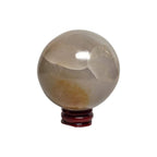 Honey calcite crystal sphere on dark red stand, translucent gray-beige with cloudy texture