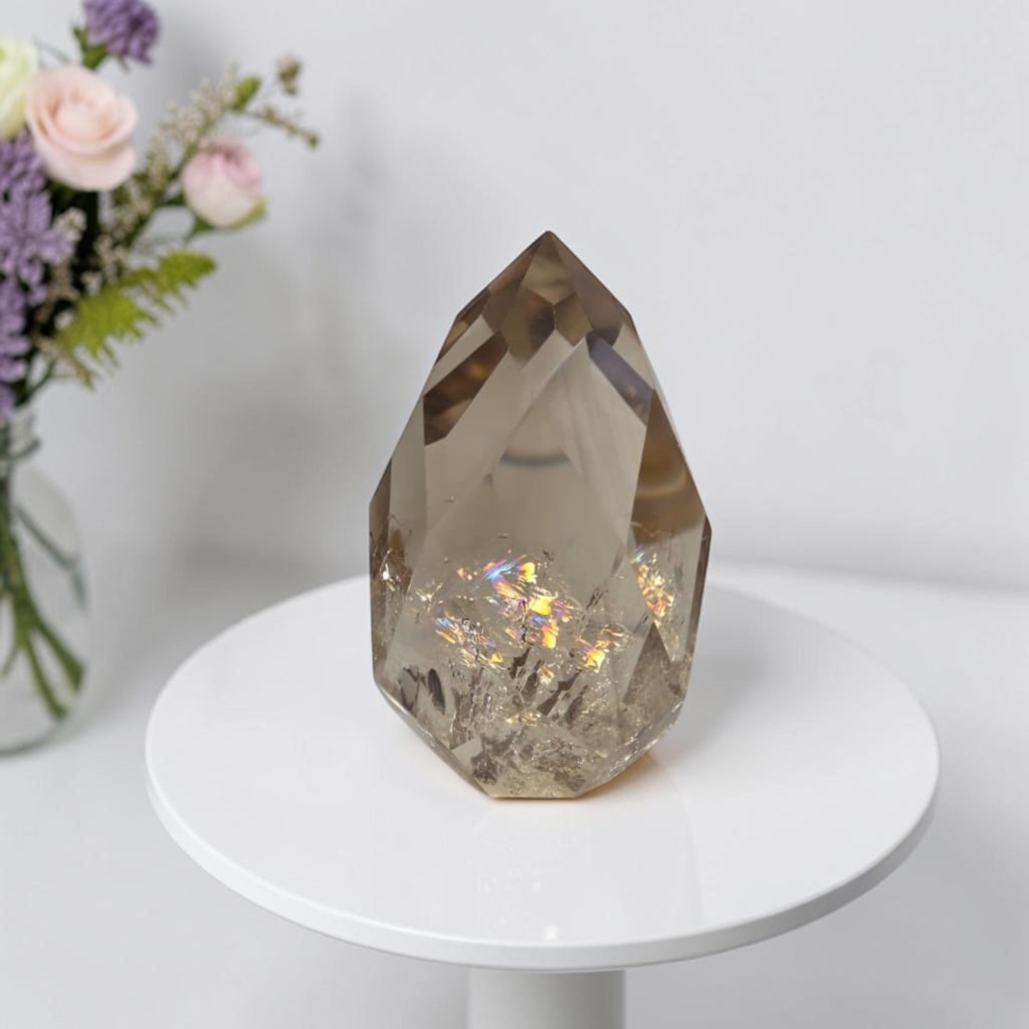 Smoky quartz crystal on gold stand, faceted clear stone with rainbow iridescent flecks
