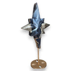 Star crystal sculpture with blue and dark gray facets on a round metal stand base.