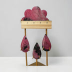 Rhodonite rain cloud crystal sculpture with ruler across top; pink cloud and hanging teardrops on stand