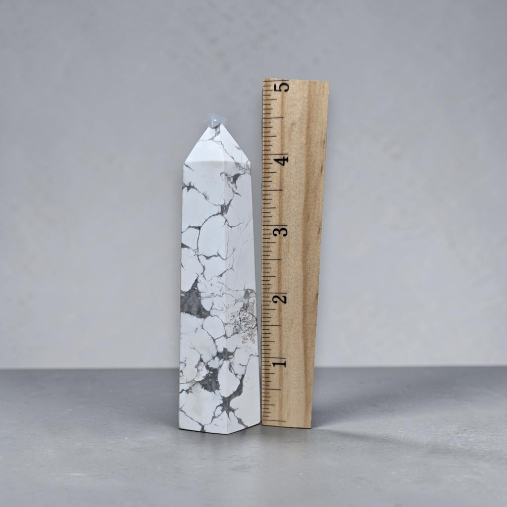 White howlite tower next to measuring tape, pointed tip