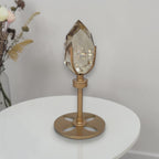 Smoky quartz crystal on rotating gold pedestal stand with faceted smoky-clear top