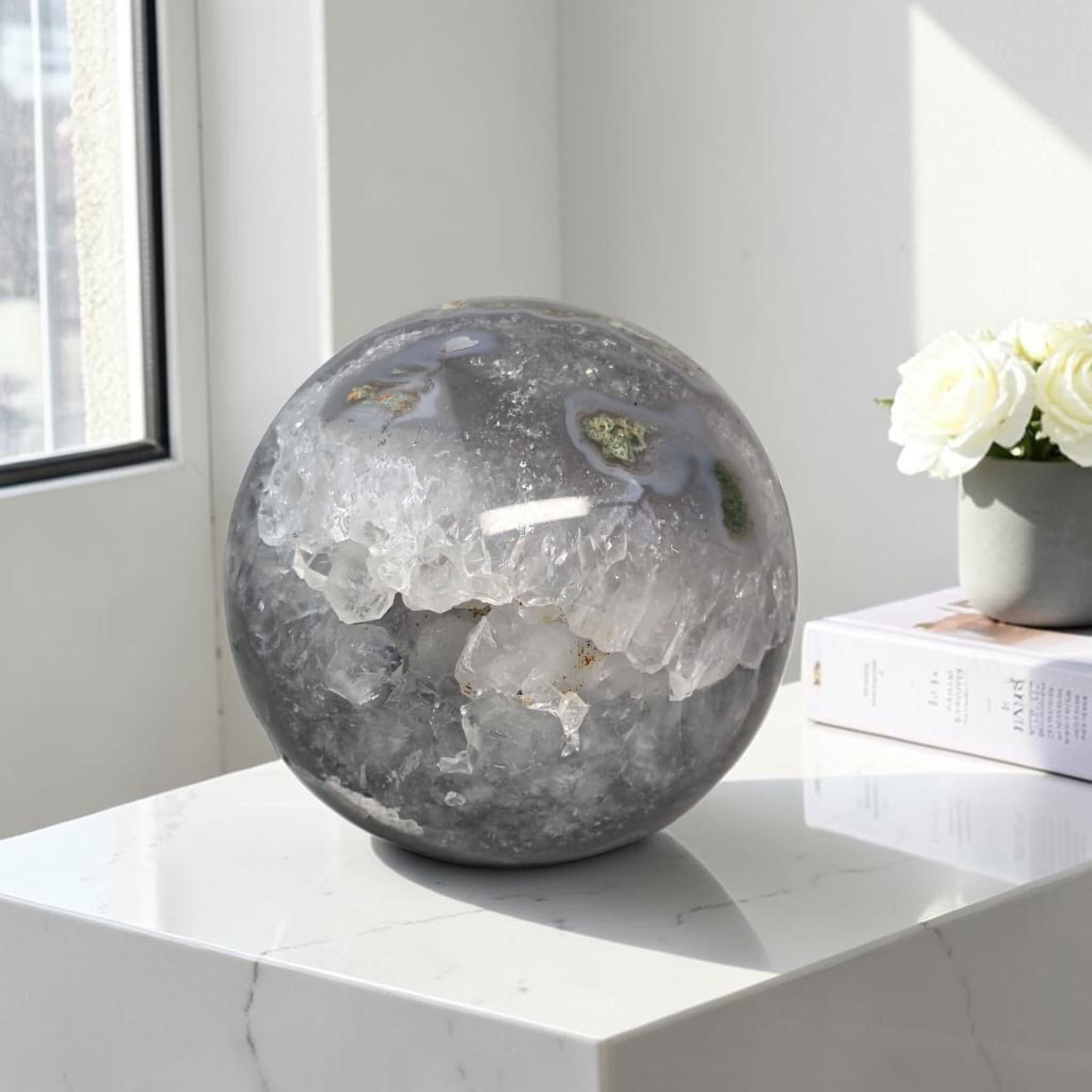 Moss agate geode sphere: dark gray-blue with white druzy center and small green specks
