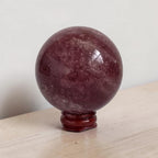 Deep red polished crystal sphere with bright highlights