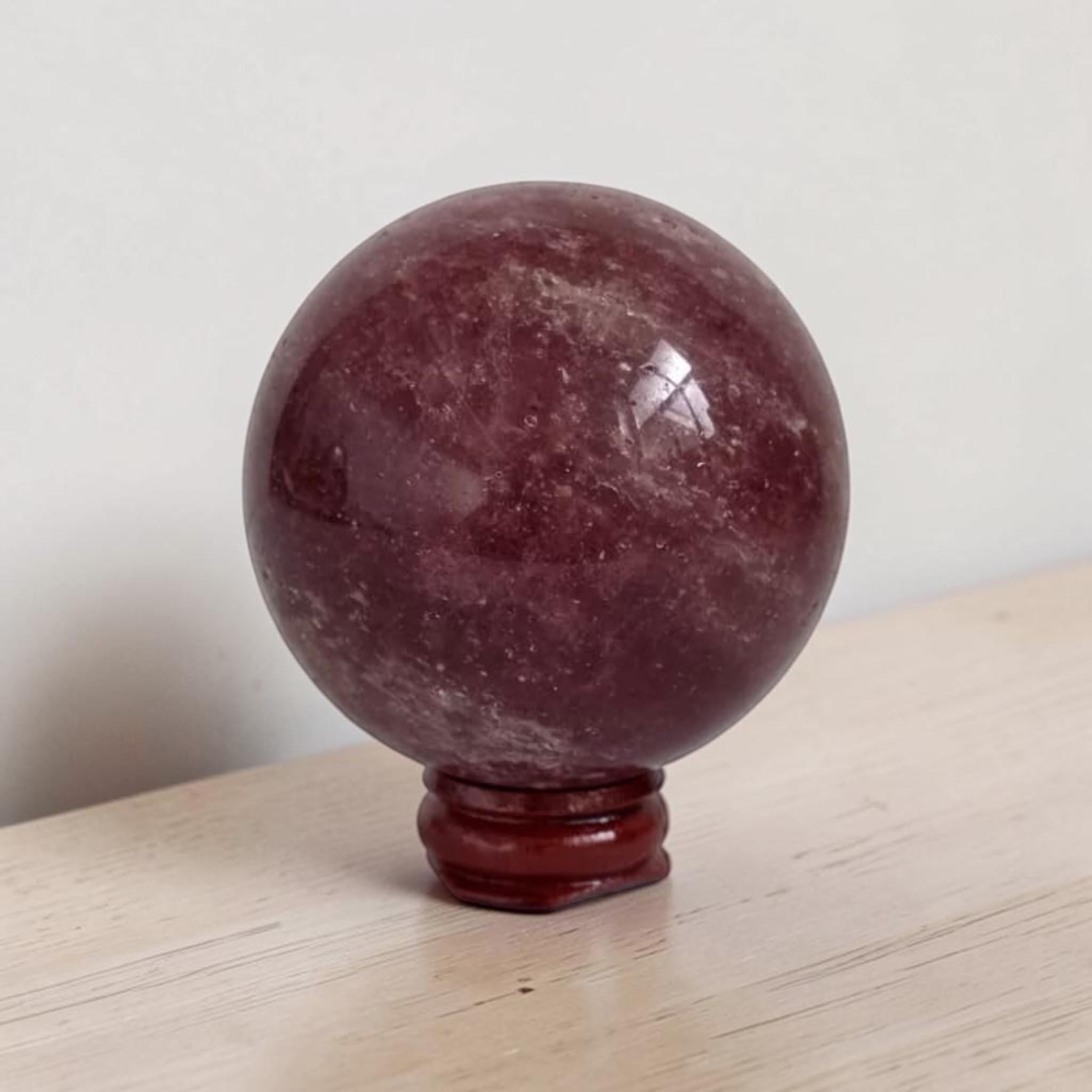 Deep red polished crystal sphere with bright highlights