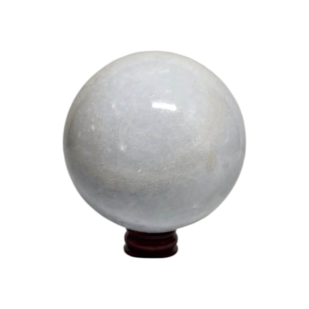 Translucent calcite sphere with glossy finish on dark wooden stand, close view