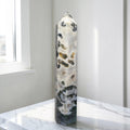 Natural crystal obelisk tower with white base and dark green speckles, pointed top