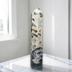 Natural crystal obelisk tower with white base and dark green speckles, pointed top