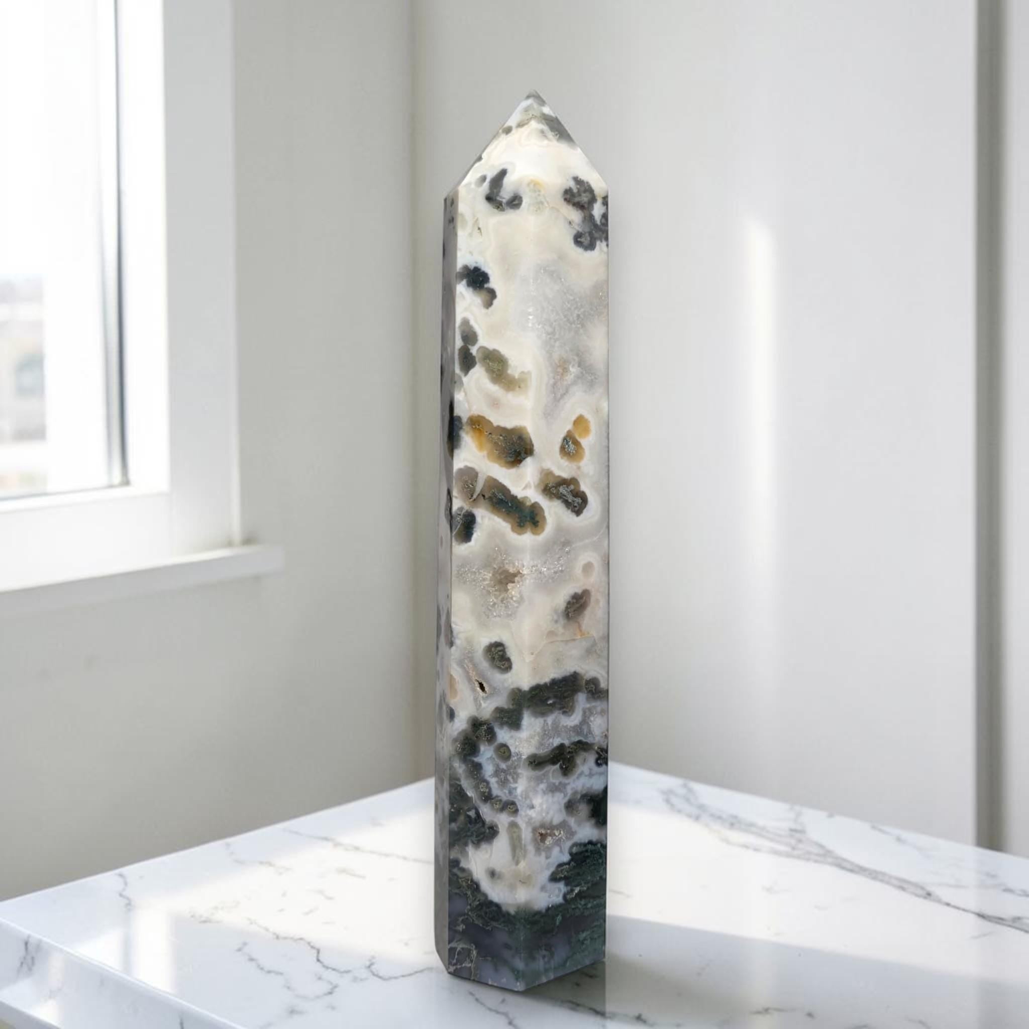 Natural crystal obelisk tower with white base and dark green speckles, pointed top