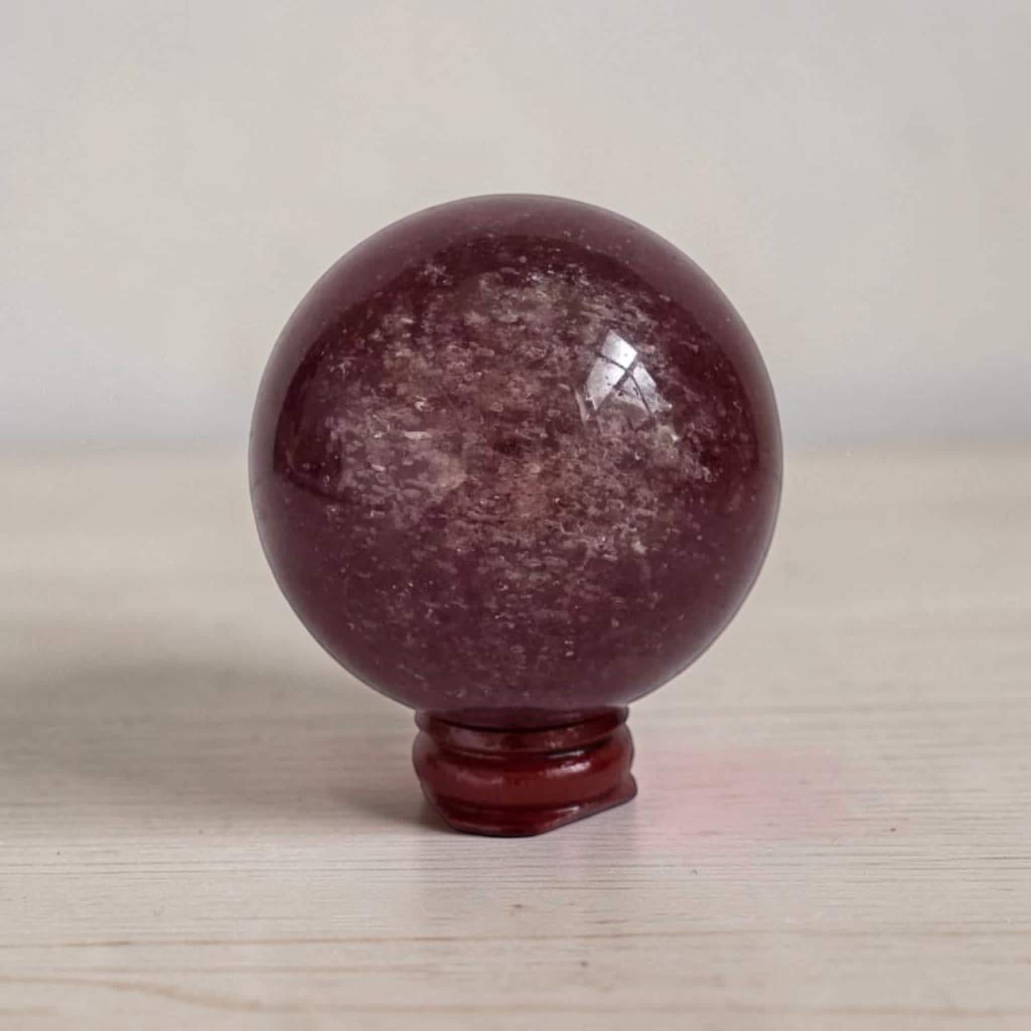 Deep red crystal sphere with glossy finish on red base