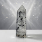 Tourmalinated quartz obelisk tower, clear stone with black needle-like inclusions.