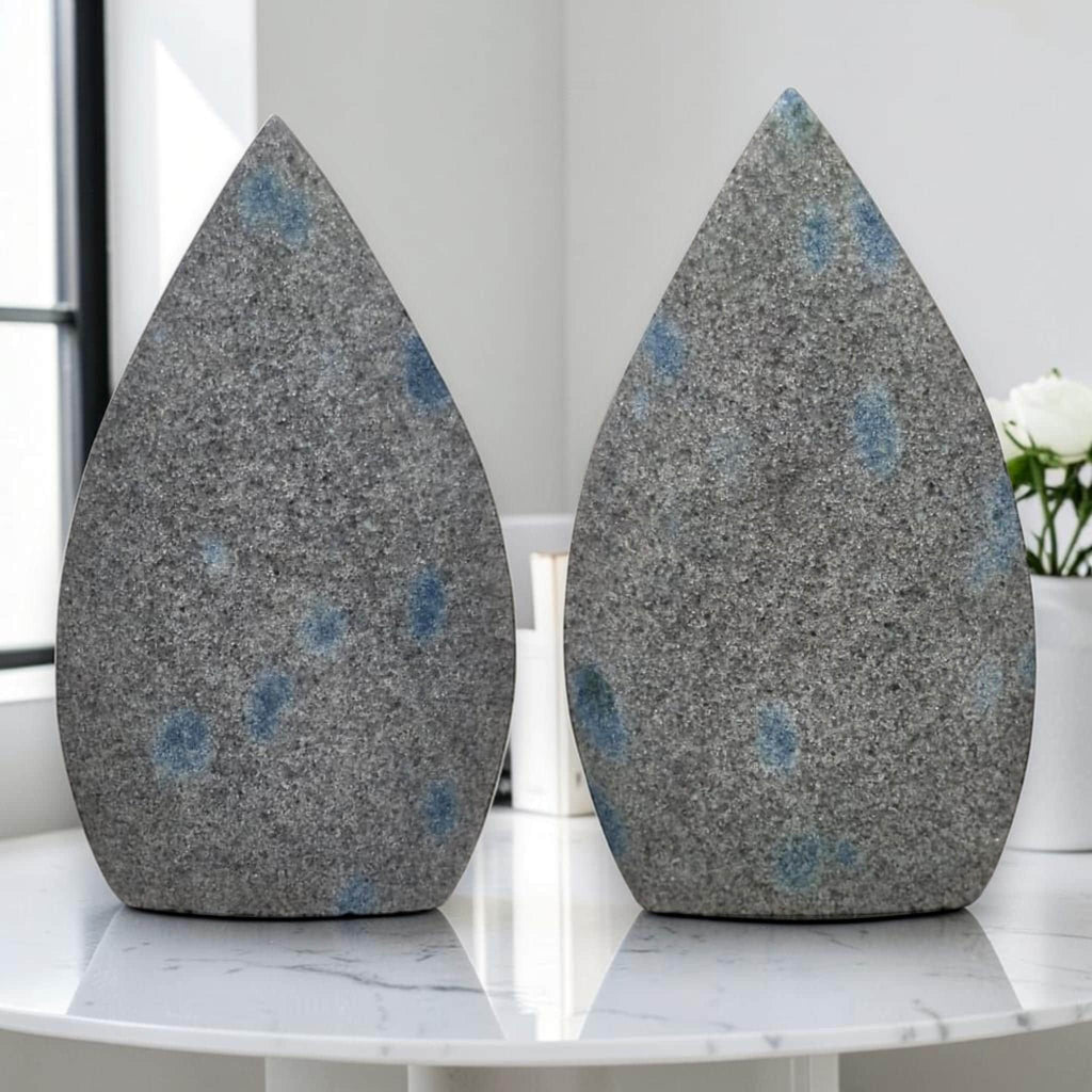 Pair of teardrop polished stones, gray with blue dot spots on front faces
