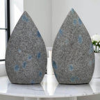 Pair of teardrop polished stones, gray with blue dot spots on front faces