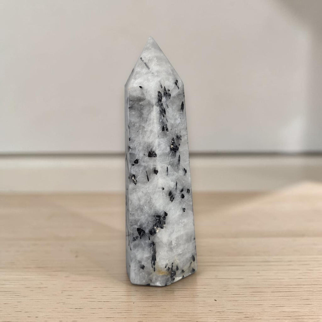 Tourmalinated quartz tower, translucent with dark crystal clusters along one face.