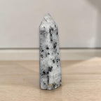 Tourmalinated quartz tower, translucent with dark crystal clusters along one face.