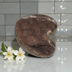 Amethyst quartz druzy freeform sculpture, dark purple glittered surface on gray base.