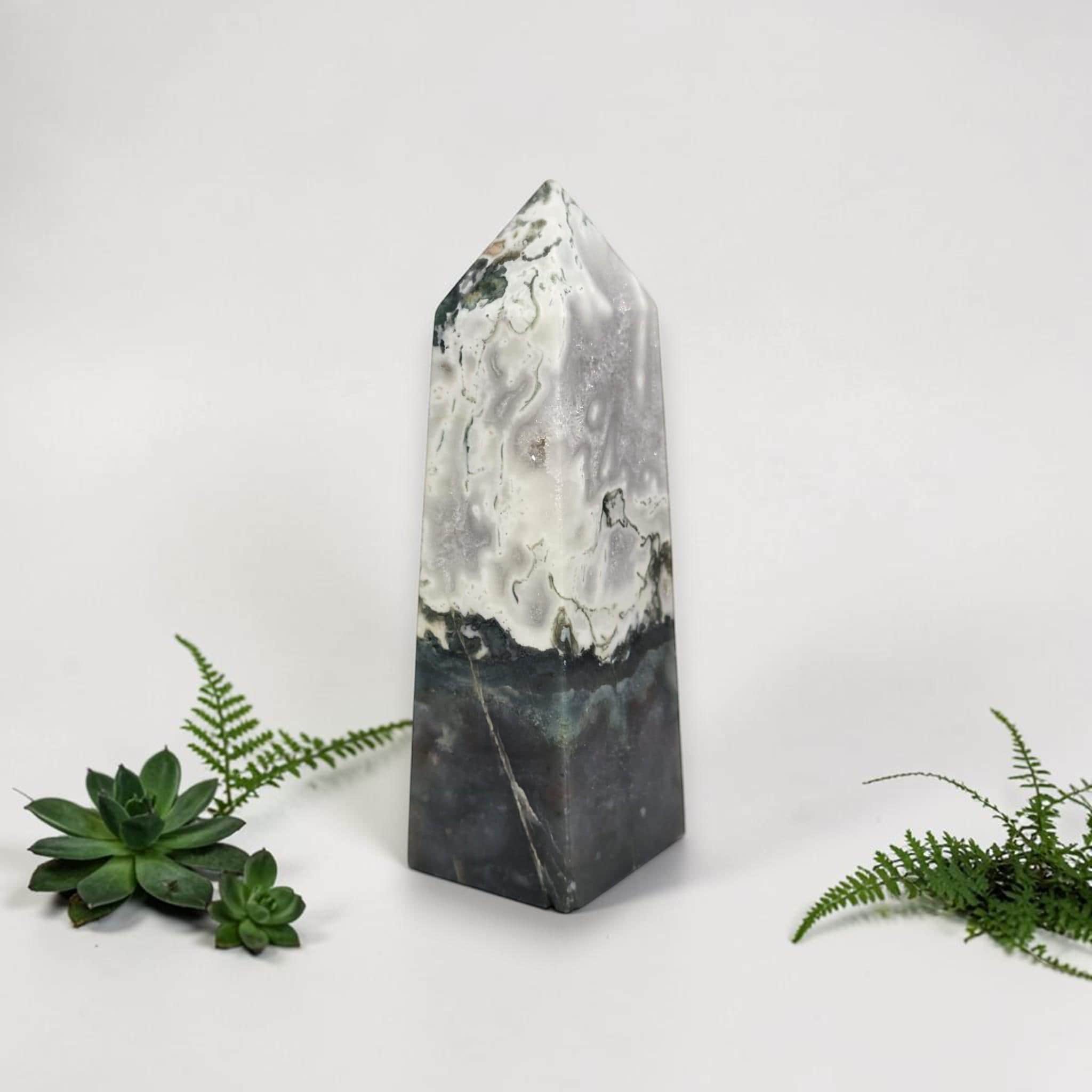 Polished agate tower, tall pointed shape with white marbling, dark bottom and wispy green patches