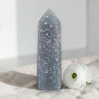 Blue angelite tower with white speckles and faceted pointed top.