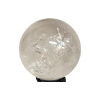 Polished clear quartz sphere gemstone with glossy surface and visible light crystal inclusions