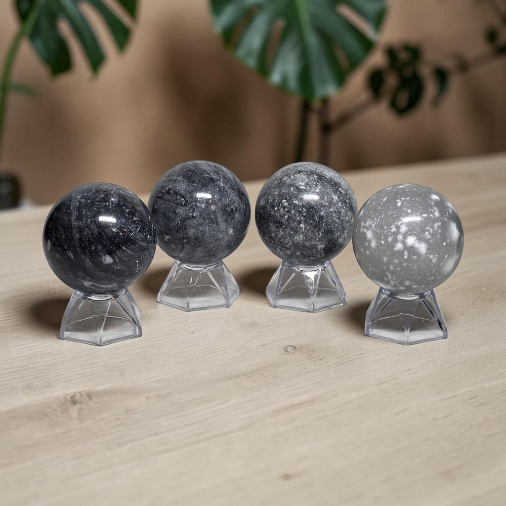 Set of jasper crystal ball spheres on clear stands, dark and light gray tones