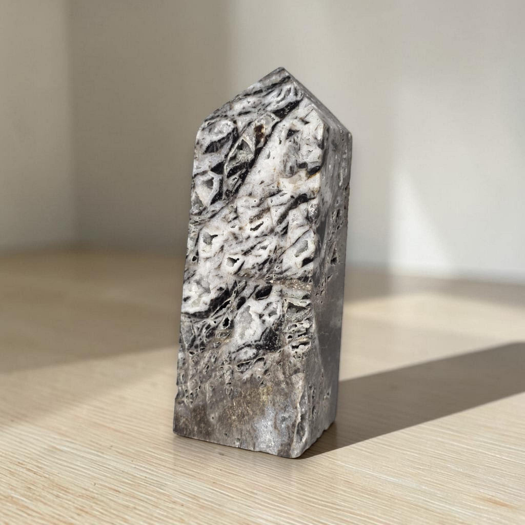 Natural sphalerite crystal tower, gray-white surface with black inclusions and striations