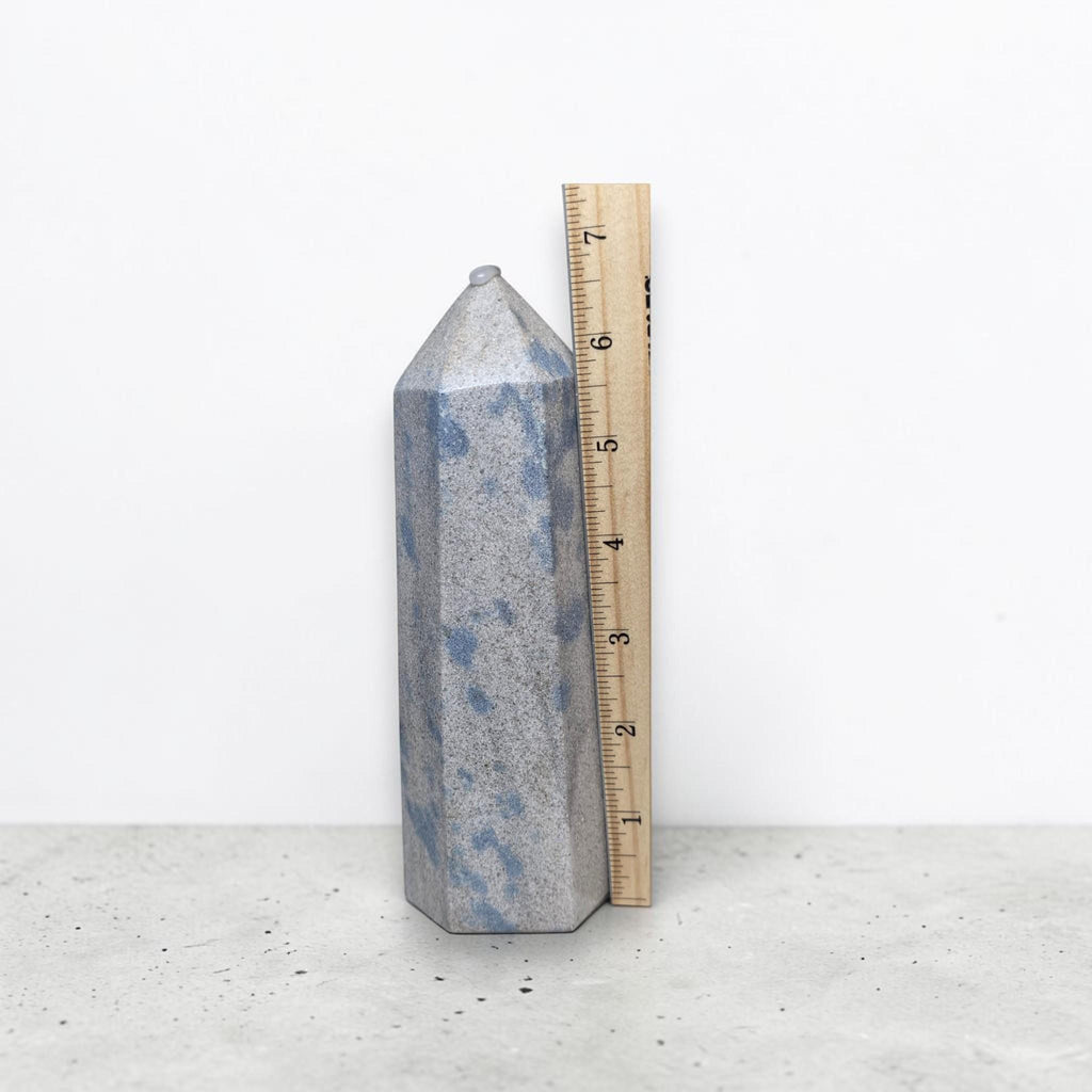 Blue speckled crystal tower with pointed top and flat faceted sides