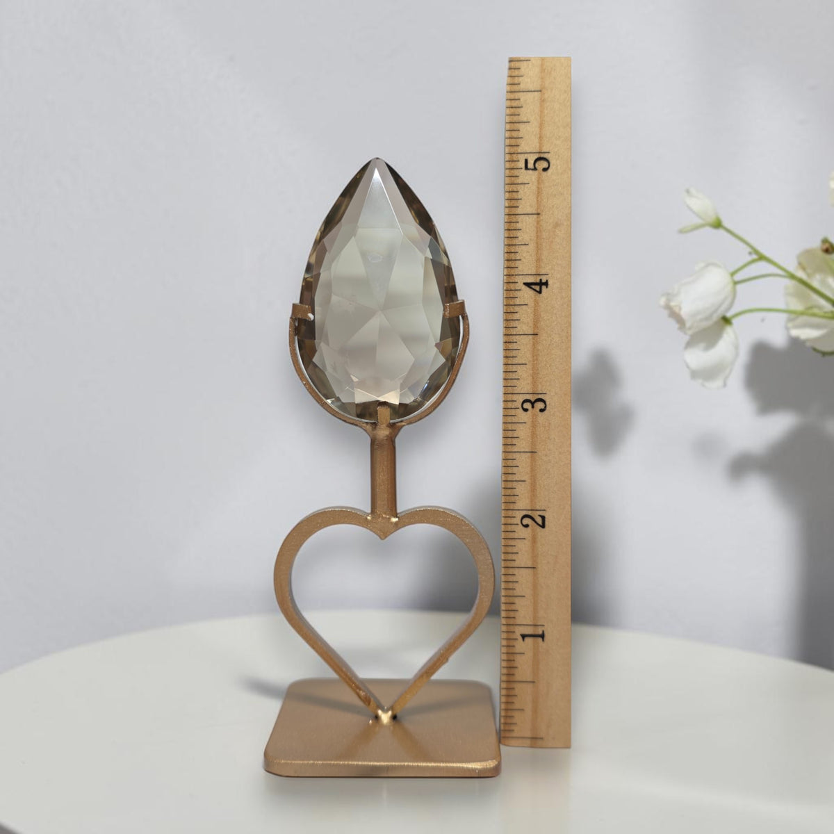 Smoky quartz teardrop with heart stand beside ruler showing 5 inches total height