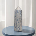 Blue and gray crystal point tower with faceted texture and rounded top knob