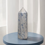 Blue and gray crystal point tower with faceted texture and rounded top knob