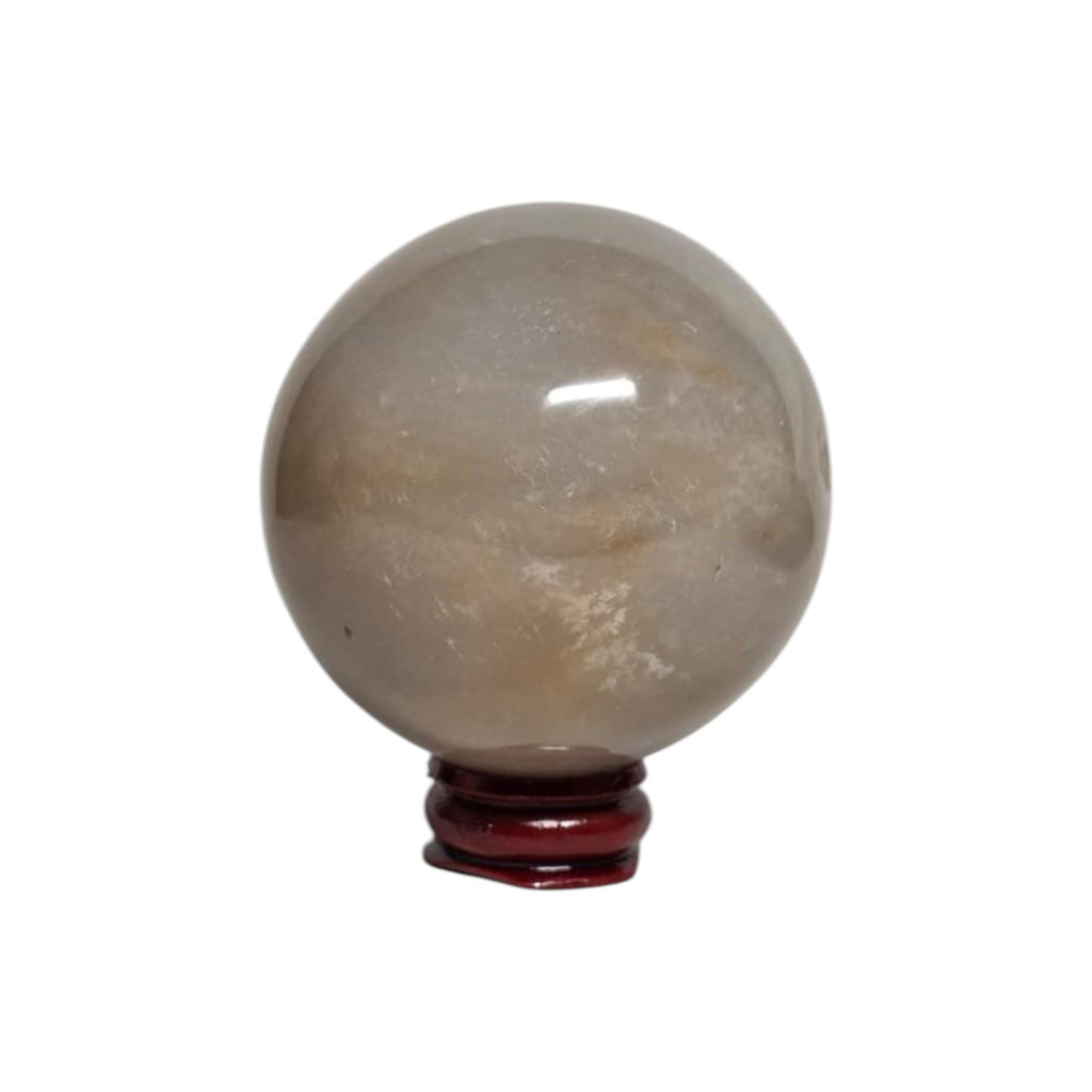 Honey calcite crystal sphere on dark red stand, translucent beige with subtle golden flecks