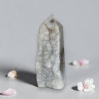 Agate drusy crystal tower with pointed top, white-gray with faint mossy green mineral spots.