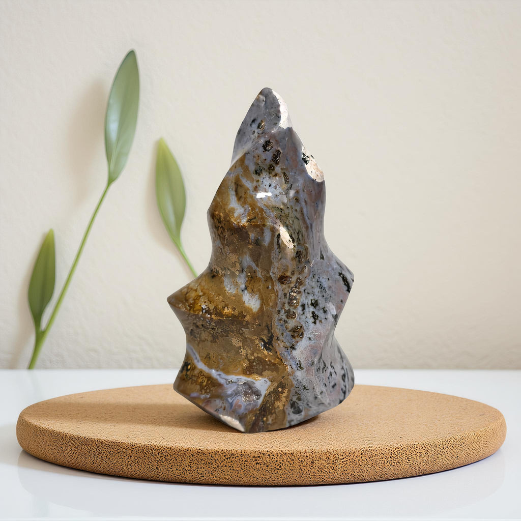 Freeform ocean jasper crystal flame on round base, blue-gray stone with gold veining