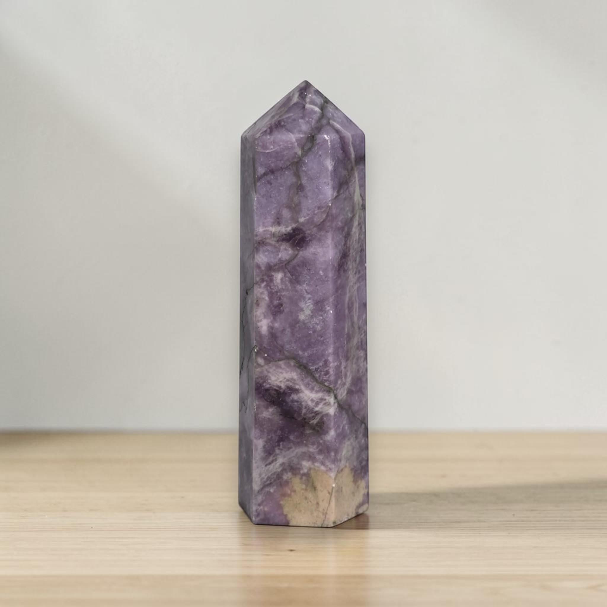 Purple crystal obelisk tower with pointed top and natural veining
