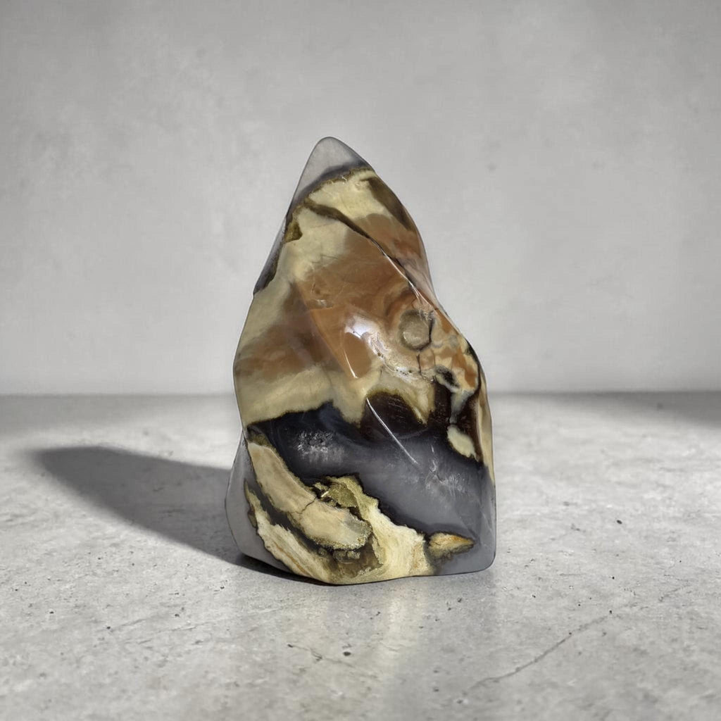 Polished agate flame-shaped stone decor with yellow-brown areas and dark gray base
