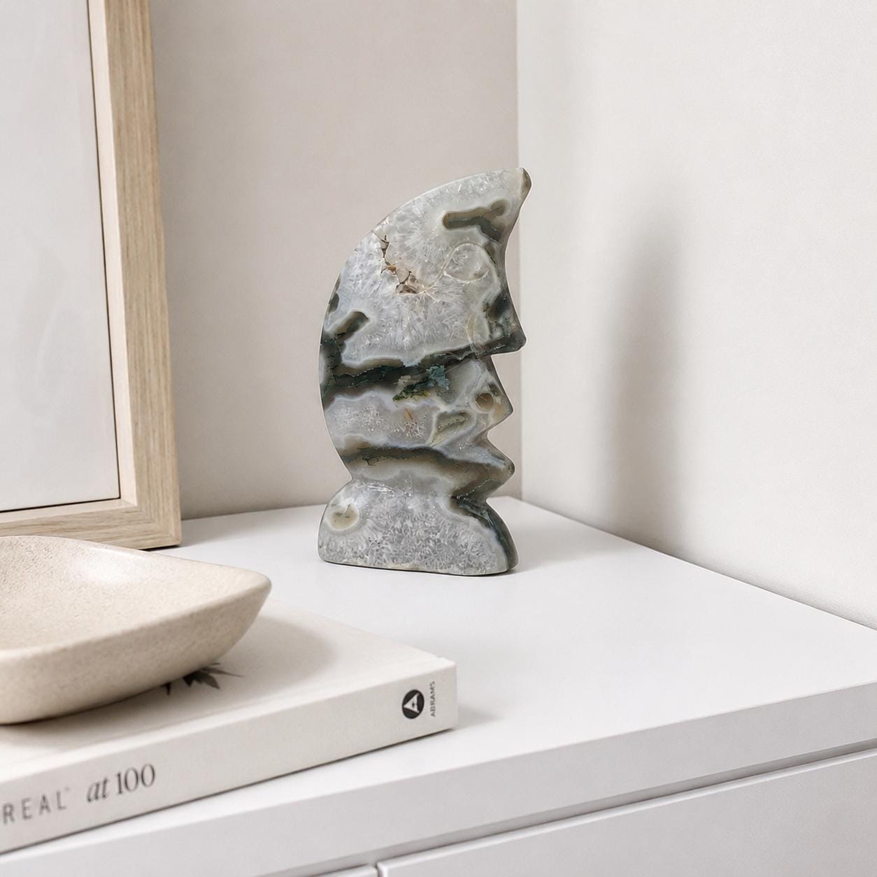 Moon face carving in moss agate, standing sculpture in light gray with green veining