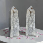 Pair of agate drusy crystal towers with pointed tops, white-gray sparkly crystals; rounded bases.
