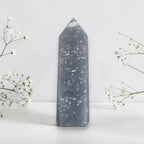 Dark blue stone tower decor with scattered white inclusions and tall pointed shape.