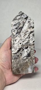 Natural sphalerite crystal tower, gray-white with black veining and speckled surface
